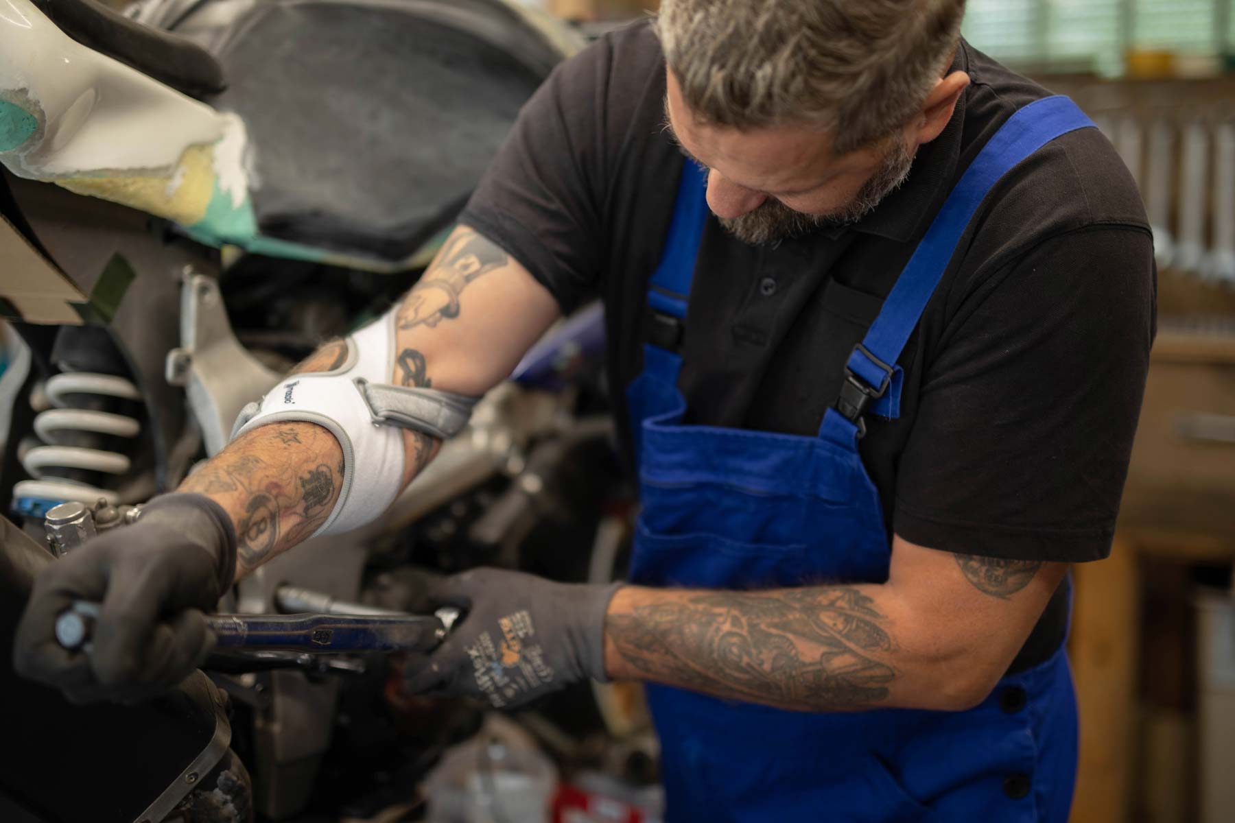 Automonteur met Masalo tennisbeugel aan het werk op een motorfiets